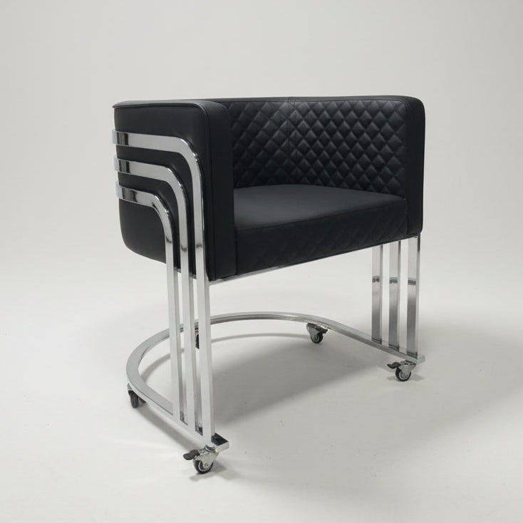 Black leather chair with chrome frame on a wooden floor, surrounded by boxes and furniture.